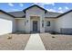 Inviting front entrance with a concrete walkway, stone accents, and a stylish gray front door at 3989 E Freeman Ln, San Tan Valley, AZ 85140