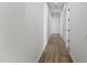 Well lit hallway featuring wood look flooring and neutral paint leading to bedrooms at 3989 E Freeman Ln, San Tan Valley, AZ 85140