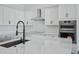 Close-up of a modern kitchen island featuring sleek countertops, a stainless steel sink, and modern appliances at 3989 E Freeman Ln, San Tan Valley, AZ 85140