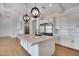 Open-concept kitchen with a large center island, white cabinets, stainless appliances, and modern pendant lighting at 3989 E Freeman Ln, San Tan Valley, AZ 85140