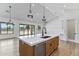 Kitchen island with a sink, stainless steel appliances, wood accents, and modern pendant lights at 3989 E Freeman Ln, San Tan Valley, AZ 85140