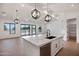 Stylish kitchen with white cabinets, stone countertops, a large island, and an open view to the living area at 3989 E Freeman Ln, San Tan Valley, AZ 85140