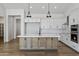 Stylish kitchen with a center island, stainless steel appliances, white cabinets, and modern fixtures at 3989 E Freeman Ln, San Tan Valley, AZ 85140