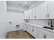 Laundry room with white cabinets, quartz counters, and wood flooring at 3989 E Freeman Ln, San Tan Valley, AZ 85140