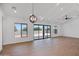 Light-filled living room with vaulted ceilings, stylish light fixture, and views of the fenced backyard at 3989 E Freeman Ln, San Tan Valley, AZ 85140