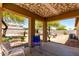 Comfortable covered patio area with neutral colors, a ceiling fan, and a view of the yard at 40264 W Lococo St, Maricopa, AZ 85138