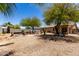 Spacious backyard with trees, gravel, and a block wall fence at 40264 W Lococo St, Maricopa, AZ 85138