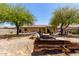 Backyard with trees, gravel, wooden planks, grill, and block wall fence at 40264 W Lococo St, Maricopa, AZ 85138