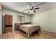 Bright bedroom featuring wood-look flooring, a ceiling fan, and natural light at 40264 W Lococo St, Maricopa, AZ 85138