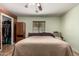 Well-lit bedroom with a ceiling fan, wood-look flooring, and a closet with ample storage at 40264 W Lococo St, Maricopa, AZ 85138