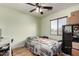 Bedroom with wood-look floors, a ceiling fan, and natural light at 40264 W Lococo St, Maricopa, AZ 85138