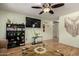 Spacious living room featuring a large television, shelving, and stylish decor at 40264 W Lococo St, Maricopa, AZ 85138