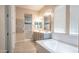 Bathroom featuring double sinks, walk-in shower, and separate tub at 4323 E Wheaton St, Gilbert, AZ 85295