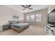 A cozy bedroom with natural light and a modern TV stand at 4323 E Wheaton St, Gilbert, AZ 85295