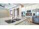 Beautiful kitchen island with stainless steel sink, white cabinets, and modern appliances at 4323 E Wheaton St, Gilbert, AZ 85295