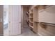Clean walk-in closet featuring a door to the bathroom, ample shelving and rods at 4323 E Wheaton St, Gilbert, AZ 85295