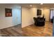 Basement area with wood floors, mounted TV, and comfortable furniture at 4902 W Vista Ave, Glendale, AZ 85301