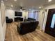 Inviting living room with wood-look floors, ceiling fan, and leather furniture set around a flat screen television at 4902 W Vista Ave, Glendale, AZ 85301
