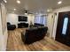 Cozy living room showcasing leather seating, a ceiling fan, modern entertainment center, and wood-look flooring at 4902 W Vista Ave, Glendale, AZ 85301