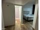 Bedroom with en suite bathroom featuring wood-look floors, tufted headboard, and a shower at 4902 W Vista Ave, Glendale, AZ 85301
