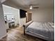 Bedroom featuring wood-look floors, ceiling fan, TV, and vanity area with lighted mirror at 4902 W Vista Ave, Glendale, AZ 85301