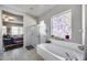Bright bathroom features a soaking tub under decorative glass window, and a nearby glass shower at 514 E Yvonne Ln, Tempe, AZ 85284