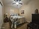 Cozy bedroom with ceiling fan, floral comforter, side table, and a dark dresser at 650 N Hawes Rd # 4007, Mesa, AZ 85207