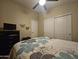 Comfortable bedroom featuring floral comforter, tv, dresser and sliding door closet at 650 N Hawes Rd # 4007, Mesa, AZ 85207