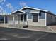 Exterior view of the home featuring a covered carport, porch, and well-maintained landscaping at 650 N Hawes Rd # 4007, Mesa, AZ 85207