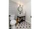 Chic powder room features a modern vanity with patterned tile flooring and black-and-white patterned accent wall at 6957 E Osborn Rd # A, Scottsdale, AZ 85251