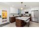 Modern kitchen features a central island with seating, wood cabinets, white counters, and stainless steel appliances at 6957 E Osborn Rd # A, Scottsdale, AZ 85251