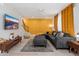 Comfortable living room with gray sectional, decorative gold wall, and bright window with gold curtains at 6957 E Osborn Rd # A, Scottsdale, AZ 85251