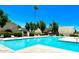Community pool with lounge chairs and shade trees on a bright, sunny day at 6957 E Osborn Rd # A, Scottsdale, AZ 85251