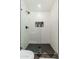 Modern walk-in shower with black fixtures, white tiled walls, and a glass partition at 6957 E Osborn Rd # A, Scottsdale, AZ 85251