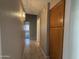 Hallway with tile flooring, a wood cabinet and sconce lighting at 7266 E Monte Ave, Mesa, AZ 85209