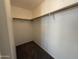 Spacious walk-in closet featuring wood-grain rods and neutral carpeting at 7266 E Monte Ave, Mesa, AZ 85209