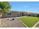 Well maintained backyard showing artificial turf, gravel area, and back of home at 7512 W Warner St, Phoenix, AZ 85043