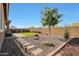 Backyard features trees, artificial turf, gravel area, BBQ, and paver patio at 7512 W Warner St, Phoenix, AZ 85043