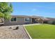 Well maintained backyard showing artificial turf, gravel area, and back of home at 7512 W Warner St, Phoenix, AZ 85043