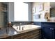 A soaking tub sits below a bright window and next to custom cabinets and tile work in this bathroom at 7512 W Warner St, Phoenix, AZ 85043