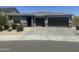Street view of a single-story home with desert landscaping and a three-car garage at 7512 W Warner St, Phoenix, AZ 85043