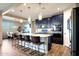 This kitchen features an island with seating, stainless steel appliances, and custom blue cabinetry at 7512 W Warner St, Phoenix, AZ 85043