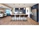 A modern eat-in kitchen features a large island with seating, stainless steel appliances, and blue cabinets at 7512 W Warner St, Phoenix, AZ 85043