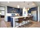 This modern eat-in kitchen includes an island with seating, stainless steel appliances, and custom blue cabinetry at 7512 W Warner St, Phoenix, AZ 85043