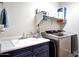 Laundry room featuring modern washer and dryer units, sink, and ample shelving for storage at 7512 W Warner St, Phoenix, AZ 85043