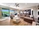 Open concept living room with wood floors, a comfortable sofa, and a view of the outdoor patio and kitchen at 7512 W Warner St, Phoenix, AZ 85043