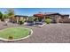 Lush backyard with turf lawn, rock landscaping, lounge chairs, outdoor dining, and BBQ at 8024 W Vista Ave, Glendale, AZ 85303