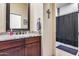 Bathroom featuring granite counters, dark wood cabinets, and a tiled shower with glass doors at 8024 W Vista Ave, Glendale, AZ 85303