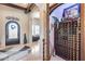 Inviting foyer with tile floors, archways, wine cellar, and decorative iron door with stylish, neutral-toned interiors at 8024 W Vista Ave, Glendale, AZ 85303