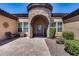 Inviting front entrance featuring a stone turret, manicured landscaping, and a decorative front door at 8024 W Vista Ave, Glendale, AZ 85303